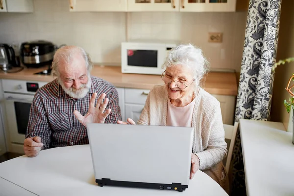 Sorridente coppia matura con documenti e laptop in casa interna — Foto Stock