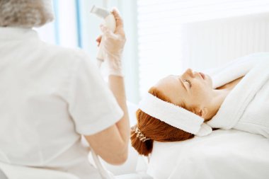 Yüz, üst görüş, güzellik tedavisi için ultrason kızılötesi kozmetoloji prosedürü.