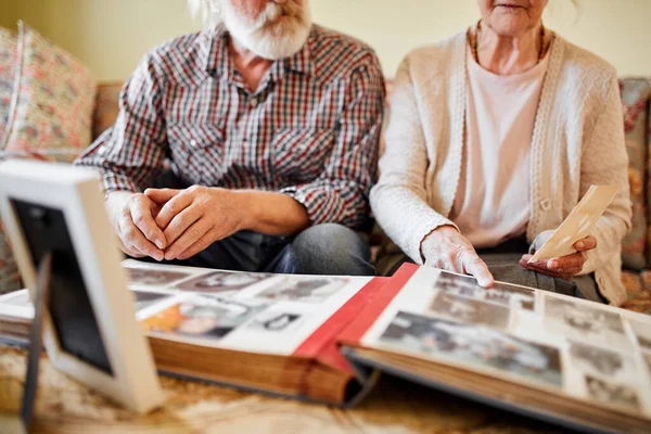 Старі люди дивляться на свій фотоальбом вдома — стокове фото