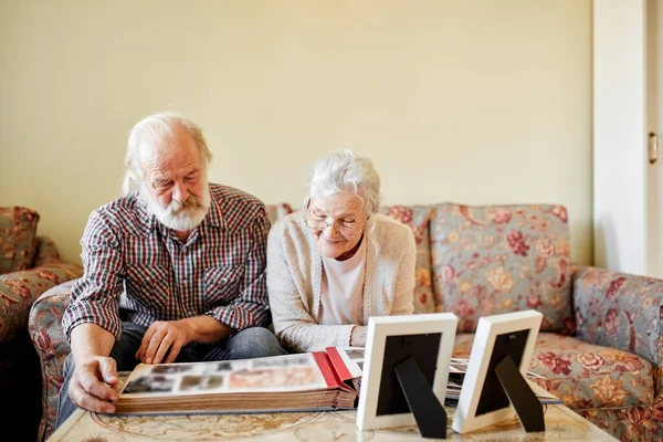 Старша пара дивиться на сімейний фотоальбом — стокове фото