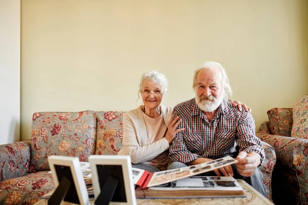 Старшая пара просматривает семейный фотоальбом — стоковое фото