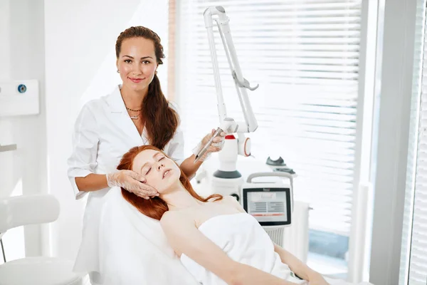 Vrouw krijgt laser gezichtsbehandeling in medisch centrum, huid verjonging concept — Stockfoto