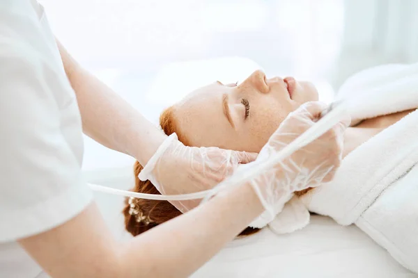 Mujer recibiendo procedimiento de descamación facial en el centro de belleza. —  Fotos de Stock