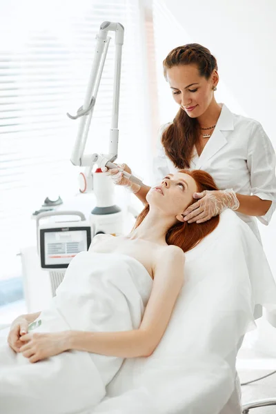 Woman getting laser face treatment in medical center, skin rejuvenation concept — Stock Photo, Image