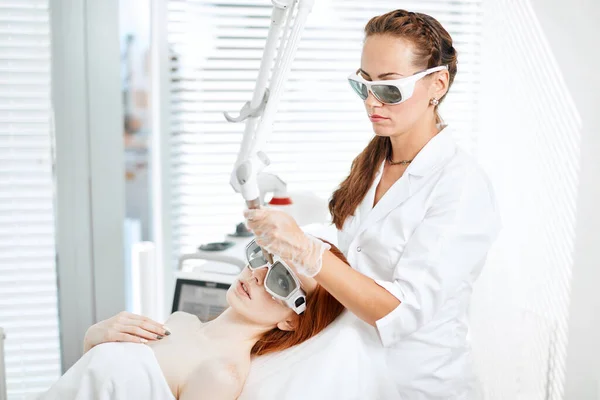 在医疗中心接受激光面部治疗的妇女，皮肤更新的概念 — 图库照片