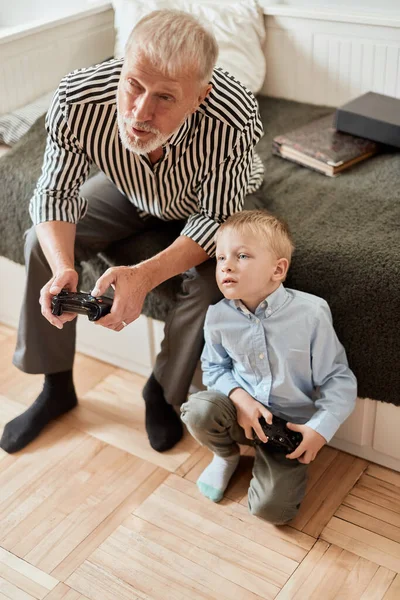 Avô e neto jogando videogames no computador com joystick — Fotografia de Stock