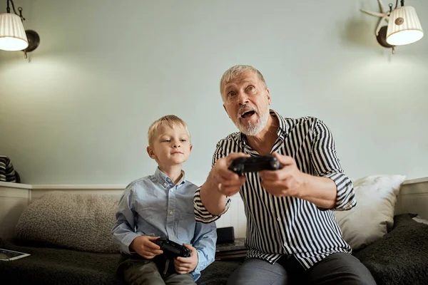 Abuelo y nieto jugando videojuegos en el ordenador con joystick — Foto de Stock