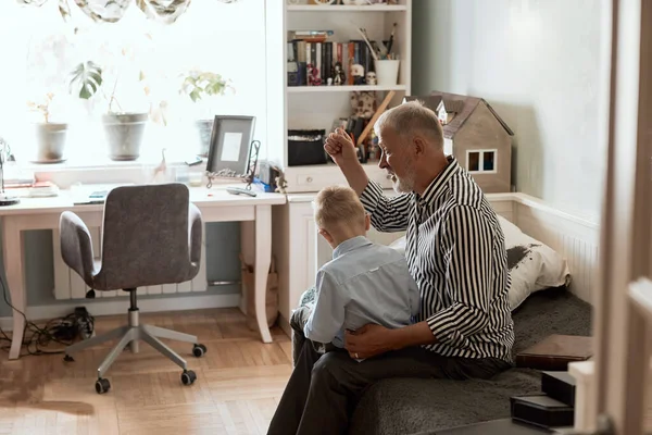 Abuelo y nieto usando tableta digital mientras están sentados en el sofá — Foto de Stock