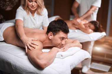 Kaplıcadaki masörden masaj alan adam.