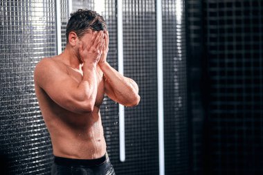 Yakışıklı adam duş alıyor, sıcak bir iş gününden sonra kendine geliyor..