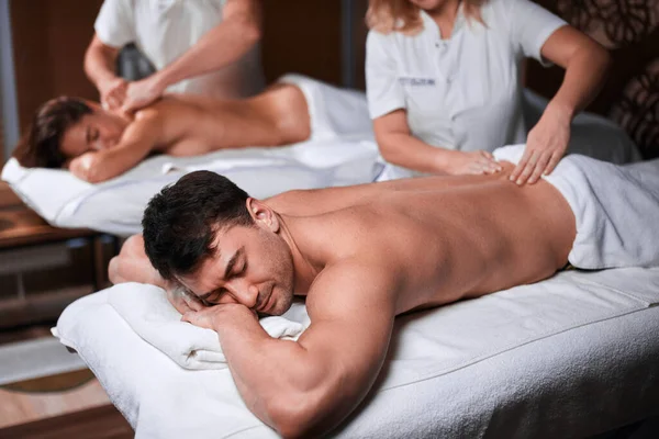 Мужчина получает массаж спины от массажиста в спа — стоковое фото