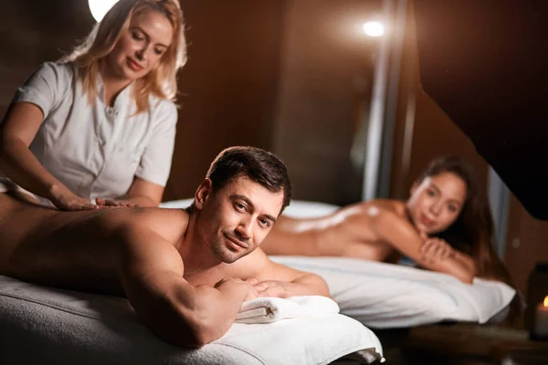 Young couple receiving a back massage in a Spa center — Stock Photo, Image