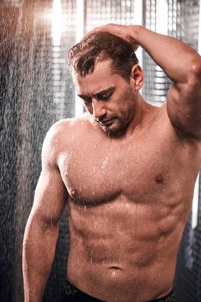 Przystojny mężczyzna bierze prysznic, odświeża się po gorącym dniu pracy. — Zdjęcie stockowe