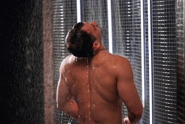 Hombre guapo tomando una ducha, refrescándose después de un día de trabajo caliente . —  Fotos de Stock