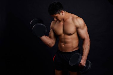 Formda, hırslı bir adam spor salonunda vakit geçiriyor.