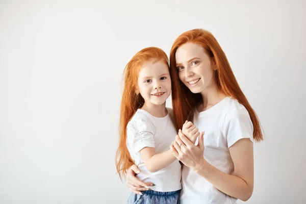 Krásné mladé červené vlasy matka objímající její roztomilé malé dítě. — Stock fotografie