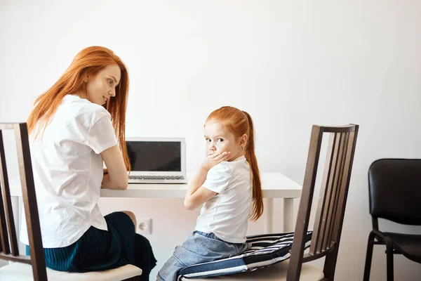 Pelirroja mamá y su linda hija viendo dibujos animados en el ordenador portátil — Foto de Stock