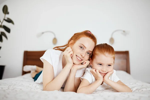 어머니와 딸은 집에서 침대에 누워서 카메라를 보는 것을 즐긴다. — 스톡 사진
