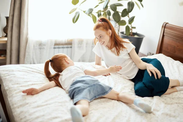 Madre e figlia godono a letto a casa e guardando la fotocamera. — Foto Stock