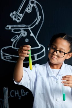 Laboratuvarda yapılan bir deney sırasında Asya kökenli Amerikalı çocuk bilim adamı elinde tüp tutuyordu.