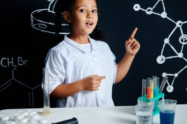 Heyecanlı ve mutlu yüzlü küçük bilim adamları laboratuarda parlak fikirlere sahipler.