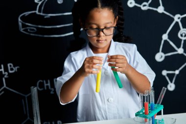 Laboratuvarda yapılan bir deney sırasında Asya kökenli Amerikalı çocuk bilim adamı elinde tüp tutuyordu.