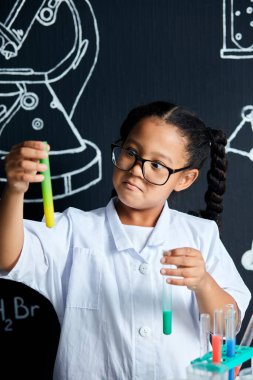 Laboratuvarda yapılan bir deney sırasında Asya kökenli Amerikalı çocuk bilim adamı elinde tüp tutuyordu.