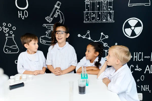 Pequenos cientistas crianças com rostos animados e felizes tendo ideia brilhante no laboratório — Fotografia de Stock