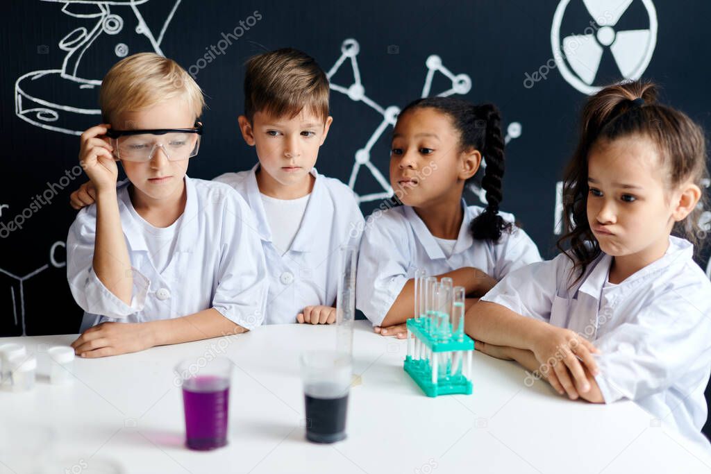 Multiracial diverse kids with test tubes studying chemistry at school laboratory