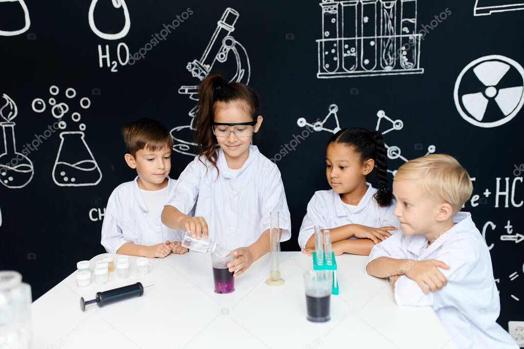 Multiracial diverse kids with test tubes studying chemistry at school laboratory