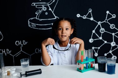 Bir grup çocuk ve öğretmen bilim deneyi yapıyorlar.