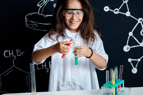 Asian American female child scientist holding tube during a experiment in lab