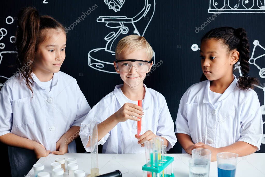 Multiracial diverse kids with test tubes studying chemistry at school laboratory