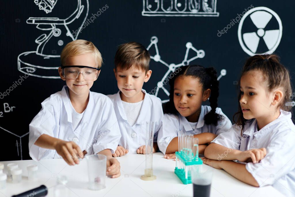 Multiracial diverse kids with test tubes studying chemistry at school laboratory