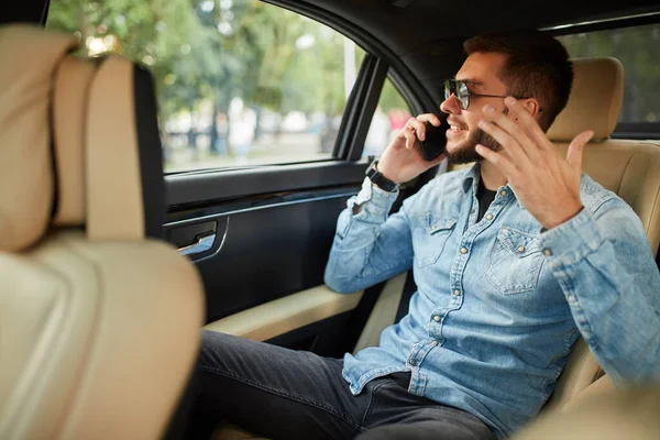 Positiver junger Mann beim Gespräch auf dem Smartphone — Stockfoto