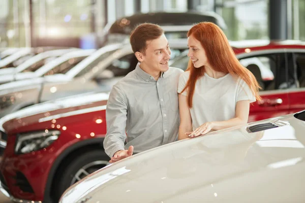 A boldog pár az első családi autót választja a bemutatóteremben. — Stock Fotó