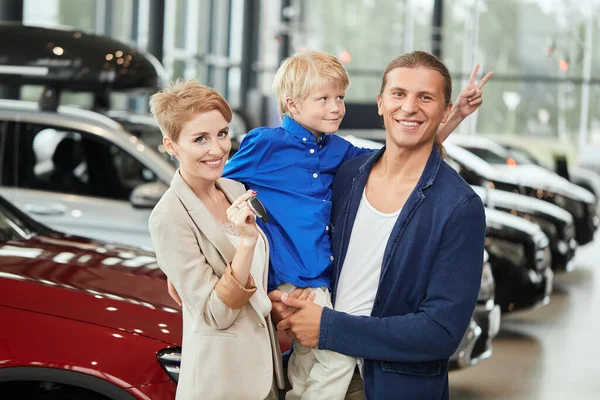 automobile sales centre. young family with child boy in car sell