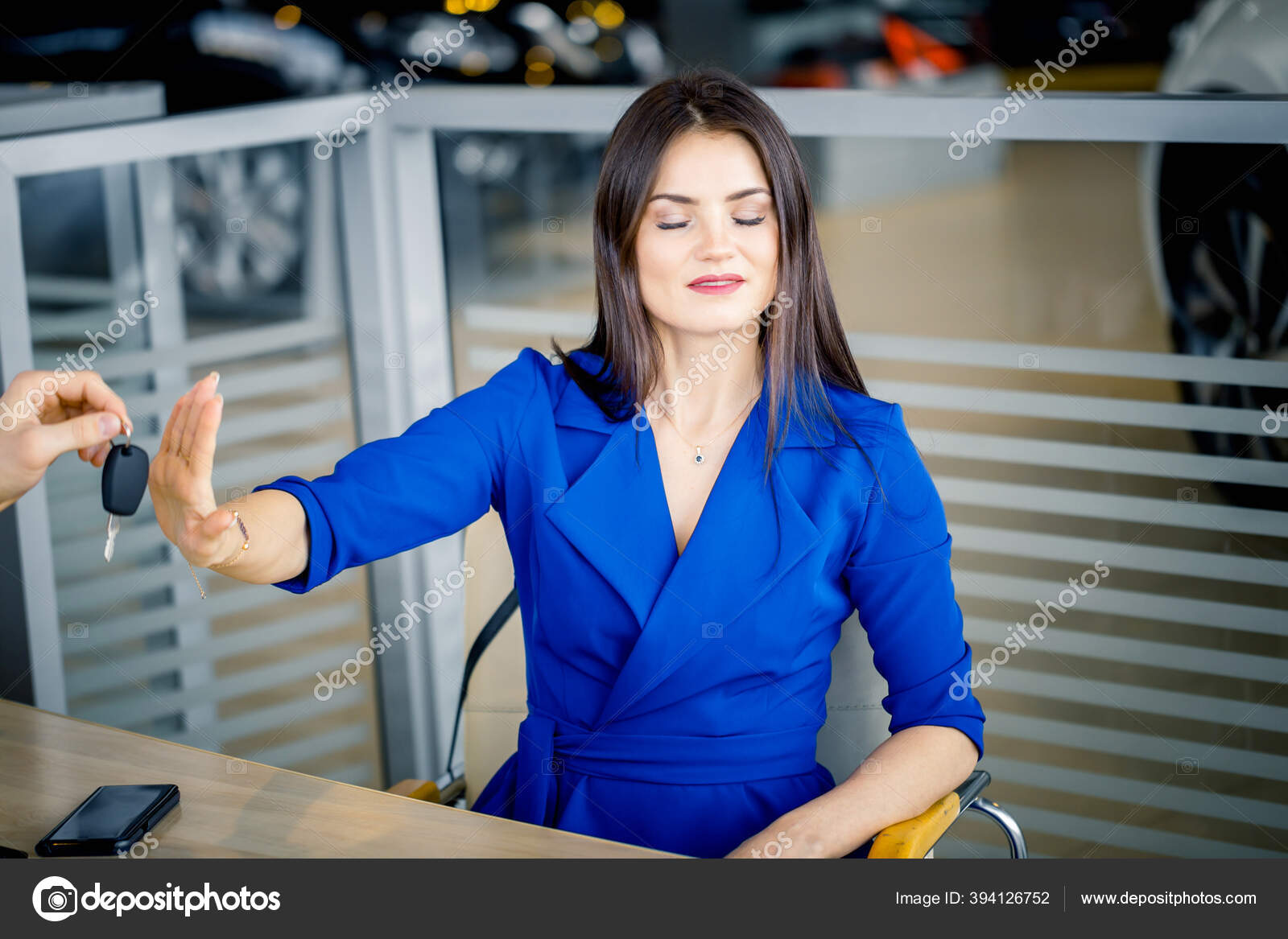 Woman refusing to take car key in autosalon Stock Photo by