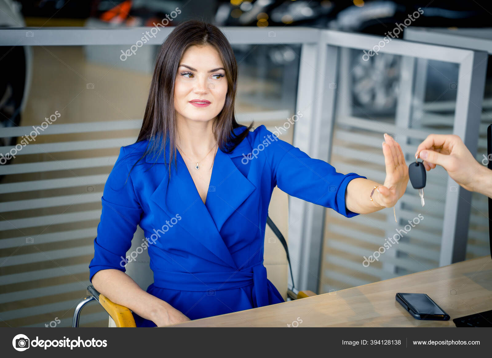 Woman refusing to take car key in autosalon — Stock Photo ©
