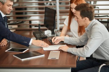 Güzel genç çift galeride evrakları imzalıyor..