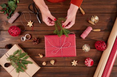 Kadın eli Noel tatili için kırmızı kutular dekore ediyor. Eller yukarı..