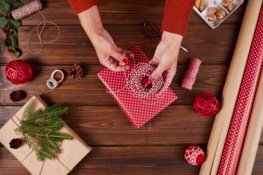 Kadın hediye paketi ve ahşap masa üzerindeki dekorasyon malzemeleri, yakın, üst görünüm.