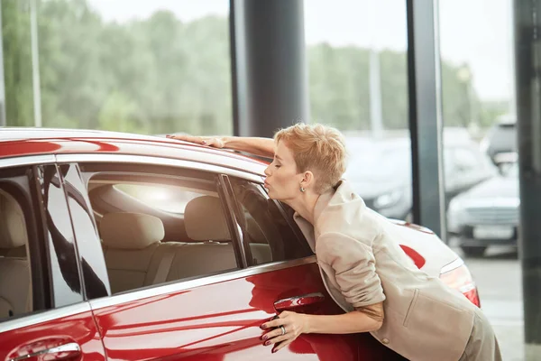 Junge Frau, die von einem neuen Auto im Autohaus überrascht, ein Geschenk  von ihrem Ehemann Stockfotografie - Alamy