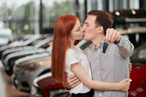 Bella coppia è in possesso di chiave della loro nuova auto, guardando la fotocamera e sorridendo — Foto Stock
