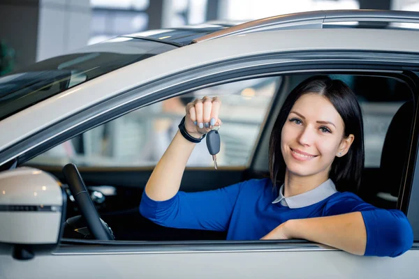Értékesítési nő mutatja az autó kulcs auto bemutatóteremben — Stock Fotó