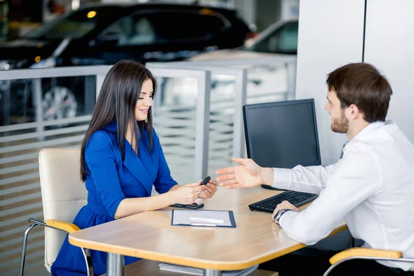 自動車販売業の営業所で契約を締結する営業女性 — ストック写真