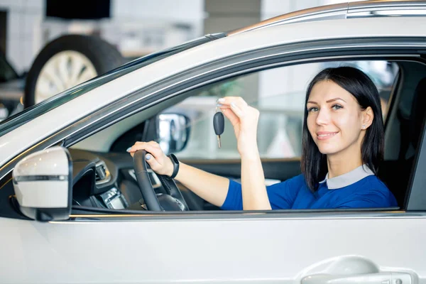 Die glückliche Frau zeigt den Schlüssel ihres neuen Autos — Stockfoto