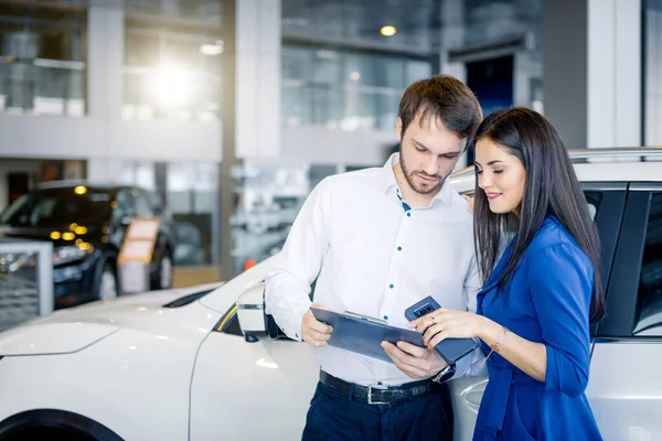 Beautiful happy couple standing near their new car — Stock Photo, Image