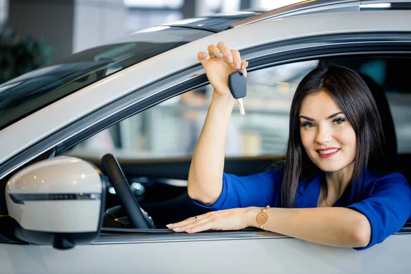 Die glückliche Frau zeigt den Schlüssel ihres neuen Autos — Stockfoto