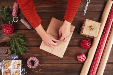 Kadın hediye paketi ve ahşap masa üzerindeki dekorasyon malzemeleri, yakın, üst görünüm.